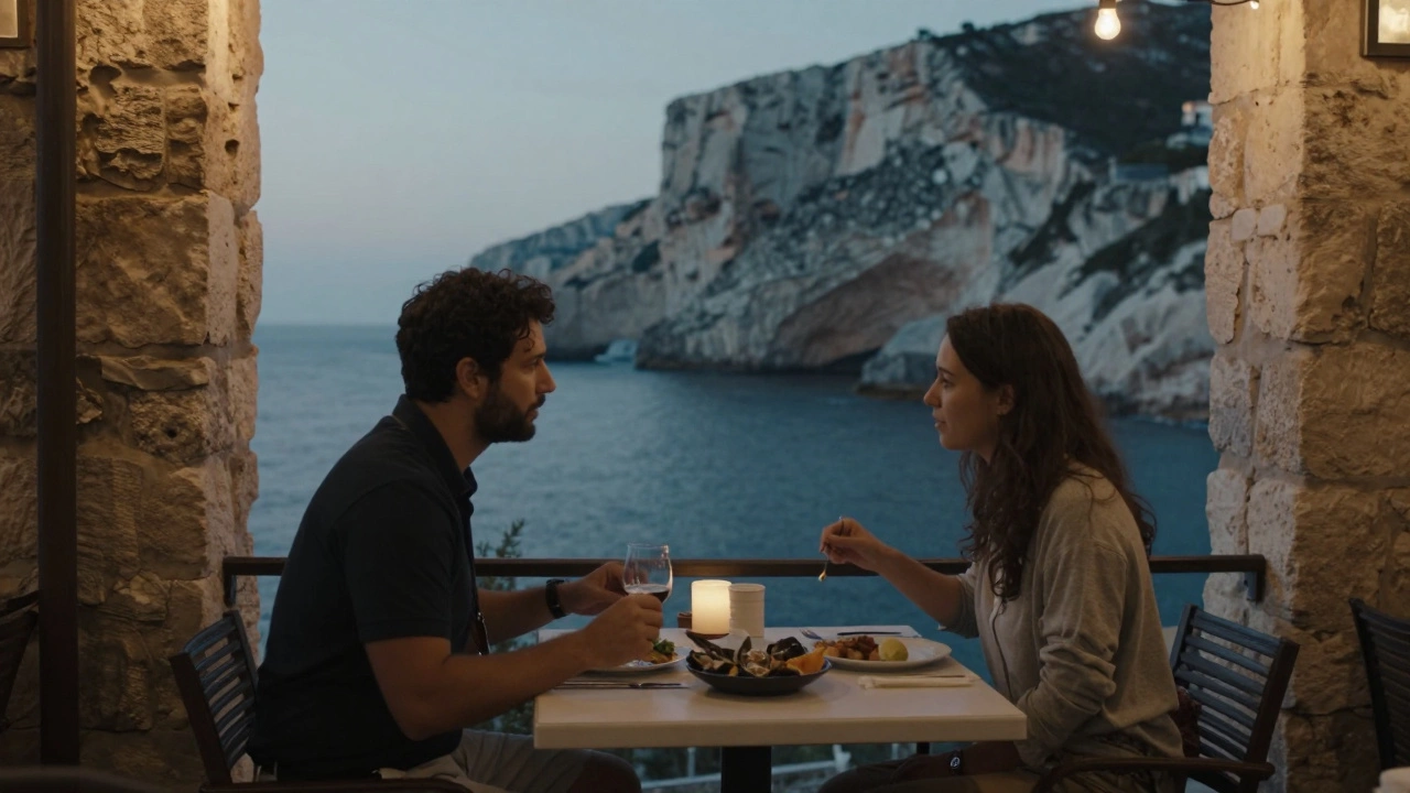 Two people enjoy a quiet dinner at a seaside café with coastal cliffs in the background.